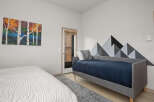 This cozy bedroom features a modern design with a unique mountain-shaped wall decor.
