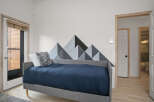 This cozy bedroom features a stylish mountain-themed accent wall, creating a unique and inviting atmosphere.