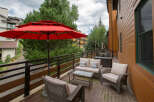 Enjoy the outdoors in style with this beautiful patio space! Featuring comfortable seating, a stylish glass-top coffee table, and a vibrant red umbrella, this outdoor area is perfect for relaxing or entertaining.