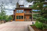 This stunning property boasts a modern design with a warm, inviting exterior featuring wood siding and large windows.