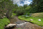 Escape to your own private oasis with this stunning property featuring a serene stream and lush greenery.