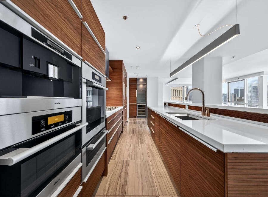 Experience luxury living in this stunning kitchen! Featuring sleek, modern appliances and rich wood cabinetry, this space is perfect for both cooking and entertaining.