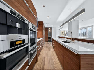 Experience luxury living in this stunning kitchen! Featuring sleek, modern appliances and rich wood cabinetry, this space is perfect for both cooking and entertaining.