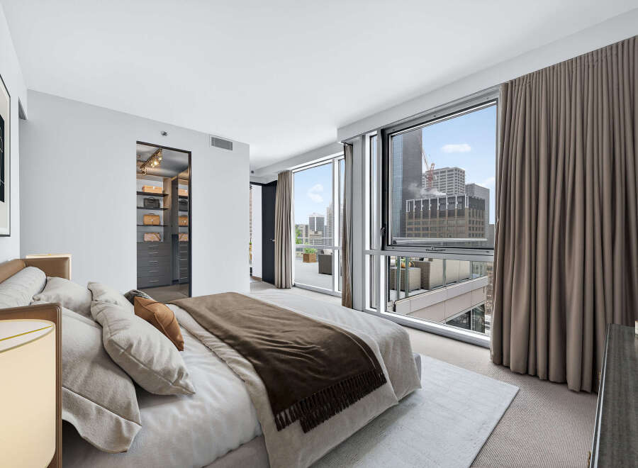 Experience luxury living in this stunning bedroom with breathtaking city views.