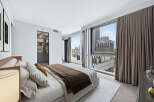 Experience luxury living in this stunning bedroom with breathtaking city views.