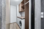 This modern laundry room features a sleek design with ample storage and functionality.