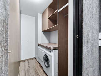 This modern laundry room features a sleek design with ample storage and functionality.