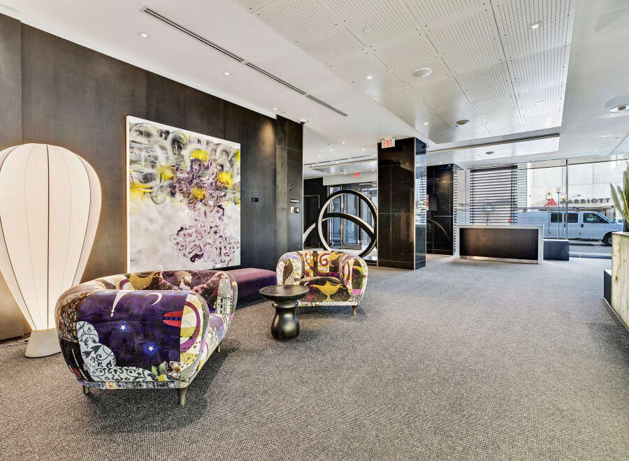Step into luxury with this stunning property, featuring a modern lobby with stylish seating and unique artwork.