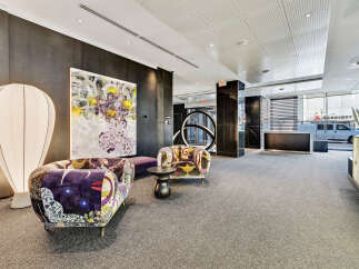 Step into luxury with this stunning property, featuring a modern lobby with stylish seating and unique artwork.