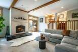 Step into the warmth of this inviting living space, featuring a cozy fireplace and a plush, comfortable sofa.