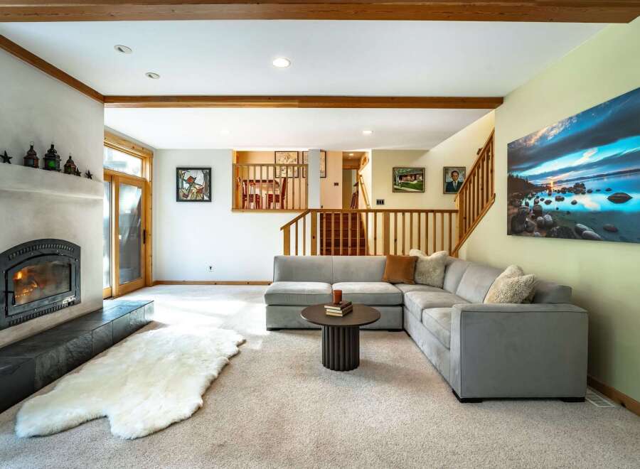 Step into luxury with this stunning property, featuring a cozy living room with a fireplace and a plush, inviting sofa.