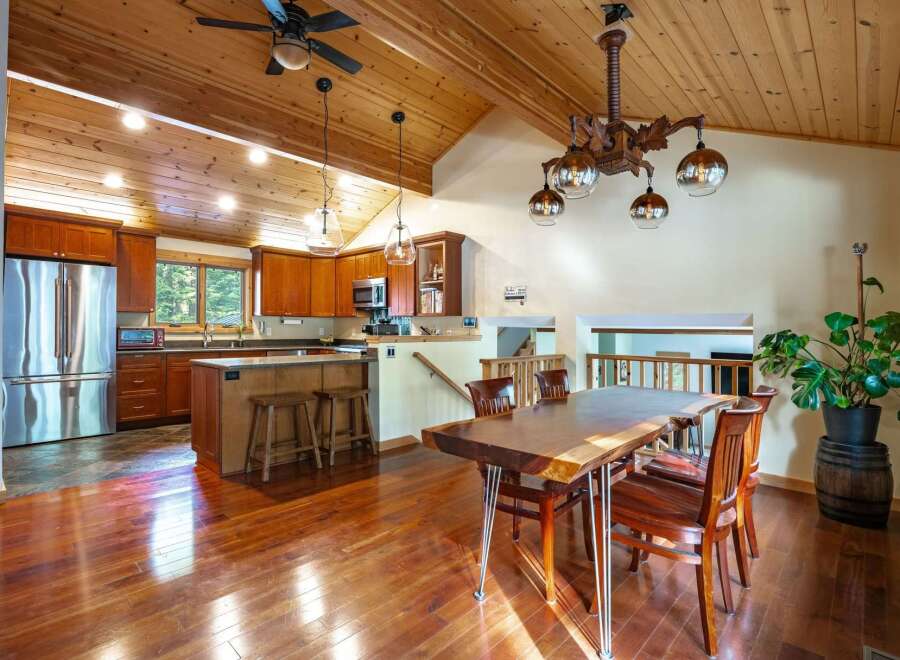 Step into this stunning home featuring a warm and inviting interior with beautiful hardwood floors and a vaulted wood ceiling.