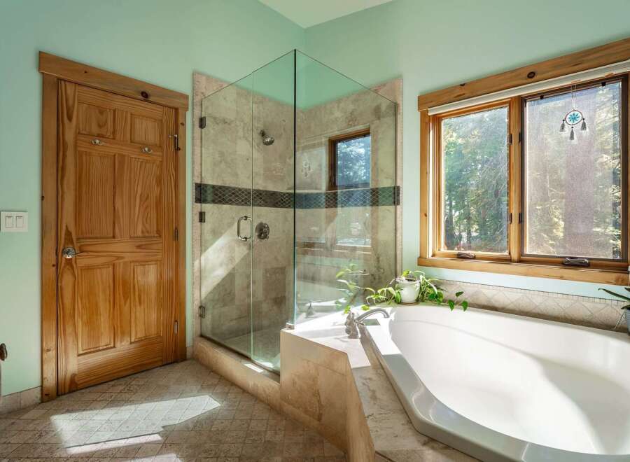 Step into a serene bathroom retreat, featuring a luxurious soaking tub and a modern glass-enclosed shower.