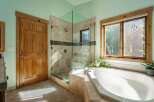 Step into a serene bathroom retreat, featuring a luxurious soaking tub and a modern glass-enclosed shower.