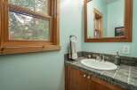 This charming bathroom features a bright, airy design with a beautiful window that offers a stunning view of the surrounding trees.