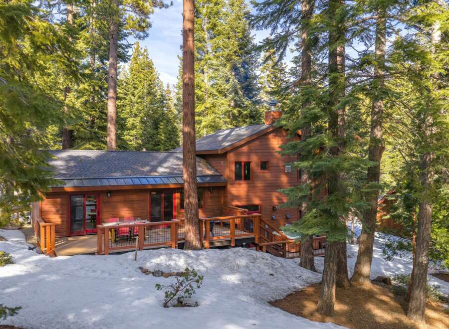 Nestled amidst towering trees and a serene snowy landscape, this stunning property offers a perfect blend of nature and luxury.