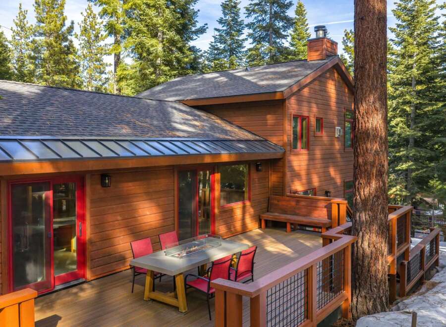 Nestled in a serene wooded setting, this stunning property boasts a beautiful wooden exterior and a spacious deck perfect for entertaining.