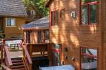 This stunning cabin boasts a beautiful wooden exterior and a relaxing hot tub, perfect for unwinding after a day of outdoor adventures.