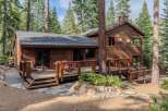 Nestled amidst towering pine trees, this charming wooden cabin offers a serene mountain retreat.