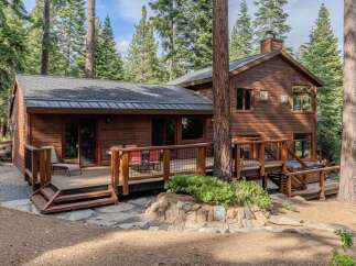 Nestled amidst towering pine trees, this charming wooden cabin offers a serene mountain retreat.