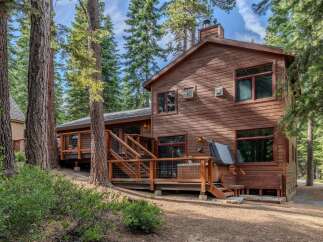 Nestled amongst towering pine trees, this charming wooden cabin offers a serene retreat.