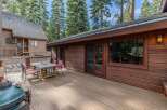 Enjoy outdoor living on this spacious wooden deck, perfect for entertaining or relaxing amidst the tall pine trees.