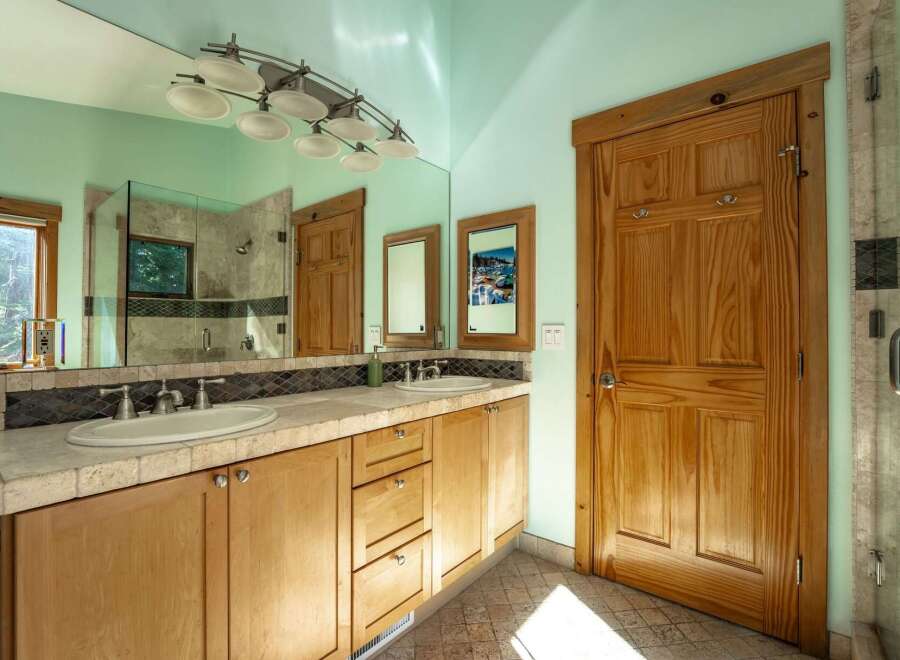 This spacious bathroom features a double vanity with ample counter space and two sinks, perfect for busy mornings.