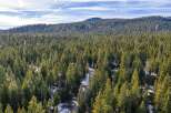 Nestled amidst a dense forest of evergreen trees, this property offers a secluded mountain retreat.