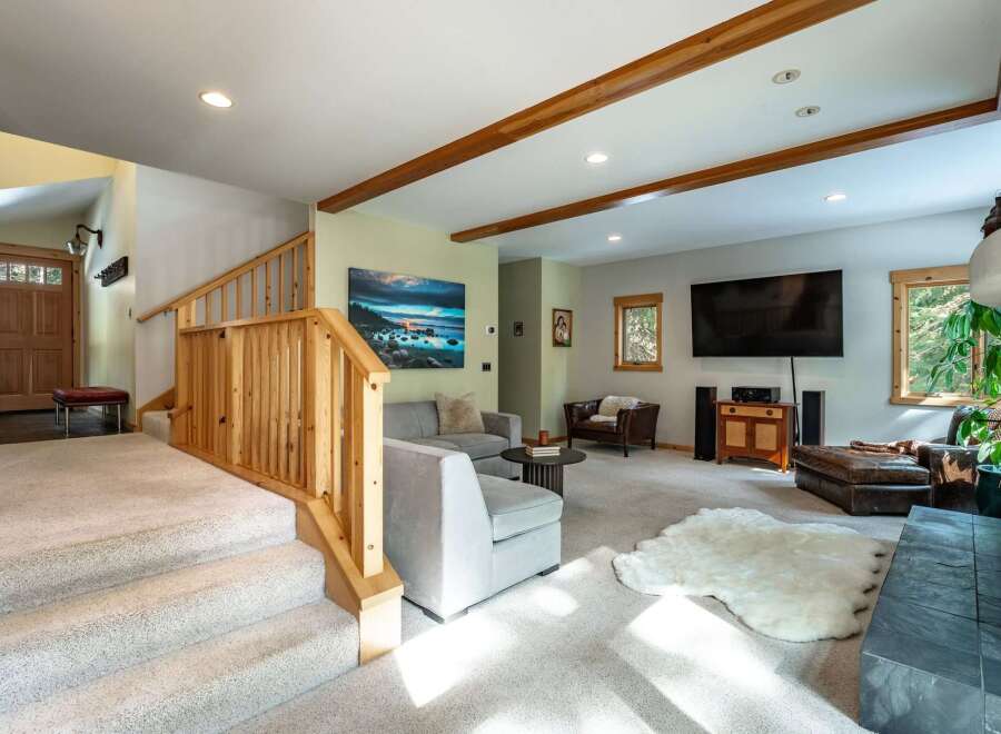 Step into this inviting living space featuring a cozy sectional sofa, a plush sheepskin rug, and a large flat-screen TV perfect for entertainment.