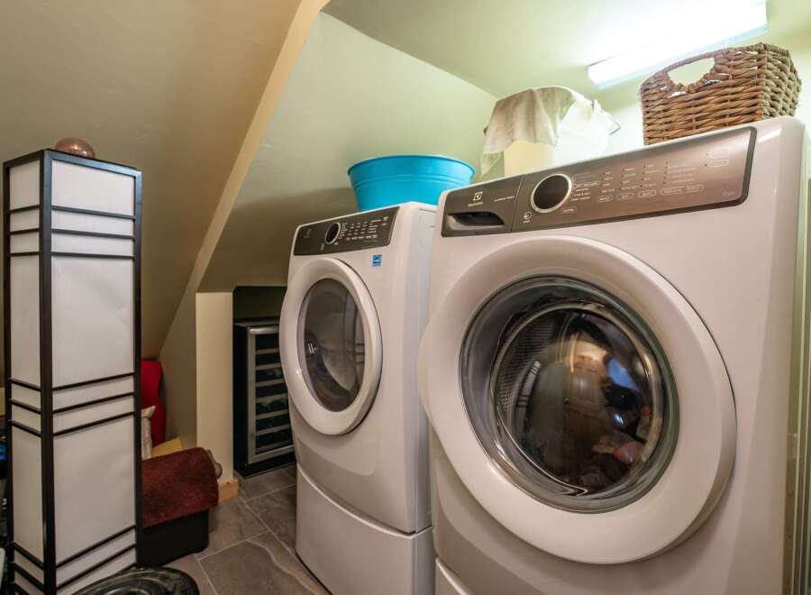 This laundry room features a stacked Electrolux washer and dryer set, perfect for maximizing space in a compact area.