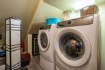 This laundry room features a stacked Electrolux washer and dryer set, perfect for maximizing space in a compact area.