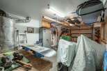 This spacious garage offers ample storage solutions, including overhead racks perfect for seasonal gear like snowboards.