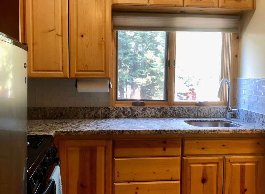 Discover this charming kitchen featuring warm, natural wood cabinetry and a spacious granite countertop.