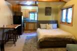 This charming studio apartment offers a cozy retreat with a well-equipped kitchenette and a comfortable queen-sized bed.