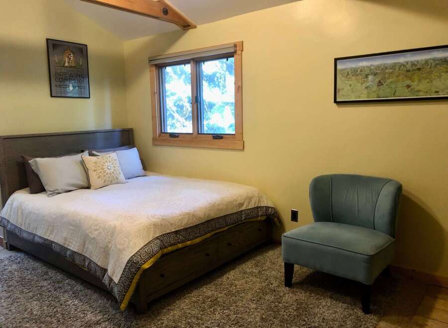 Discover comfort and style in this inviting bedroom, featuring a plush queen-size bed adorned with decorative pillows and a cozy duvet.