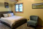 Discover comfort and style in this inviting bedroom, featuring a plush queen-size bed adorned with decorative pillows and a cozy duvet.