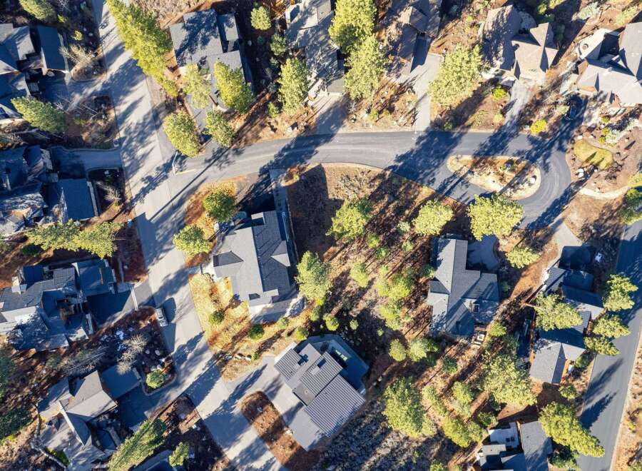 Discover a stunning aerial view of a luxurious neighborhood featuring modern homes with dark gray roofs.
