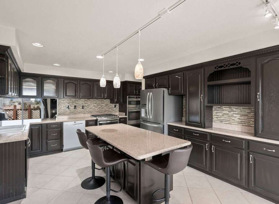 This stunning kitchen boasts dark wood cabinetry, offering a sophisticated and timeless aesthetic.