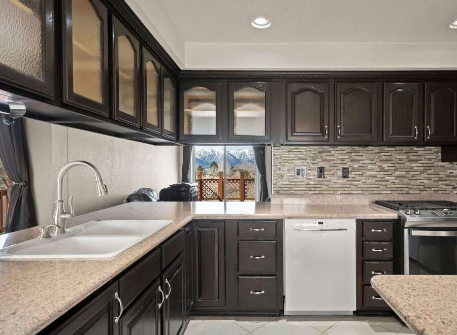 This stunning kitchen boasts dark wood cabinetry, offering a sophisticated and timeless aesthetic.