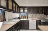 This stunning kitchen boasts dark wood cabinetry, offering a sophisticated and timeless aesthetic.