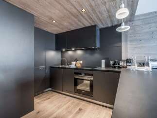 This modern kitchen boasts sleek, dark cabinetry and a minimalist design, perfect for a contemporary home.