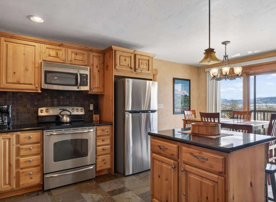 This stunning kitchen boasts beautiful wooden cabinetry and stainless steel appliances, creating a warm and inviting atmosphere.
