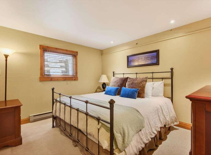 This inviting bedroom features a comfortable bed with plush pillows and a cozy blanket, perfect for a relaxing retreat.
