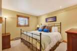 This inviting bedroom features a comfortable bed with plush pillows and a cozy blanket, perfect for a relaxing retreat.