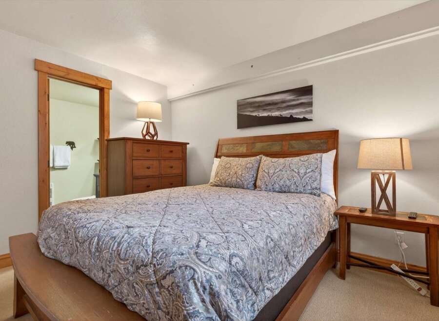 This cozy bedroom features a comfortable bed with a stylish patterned comforter, perfect for a relaxing retreat.