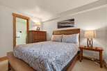 This cozy bedroom features a comfortable bed with a stylish patterned comforter, perfect for a relaxing retreat.