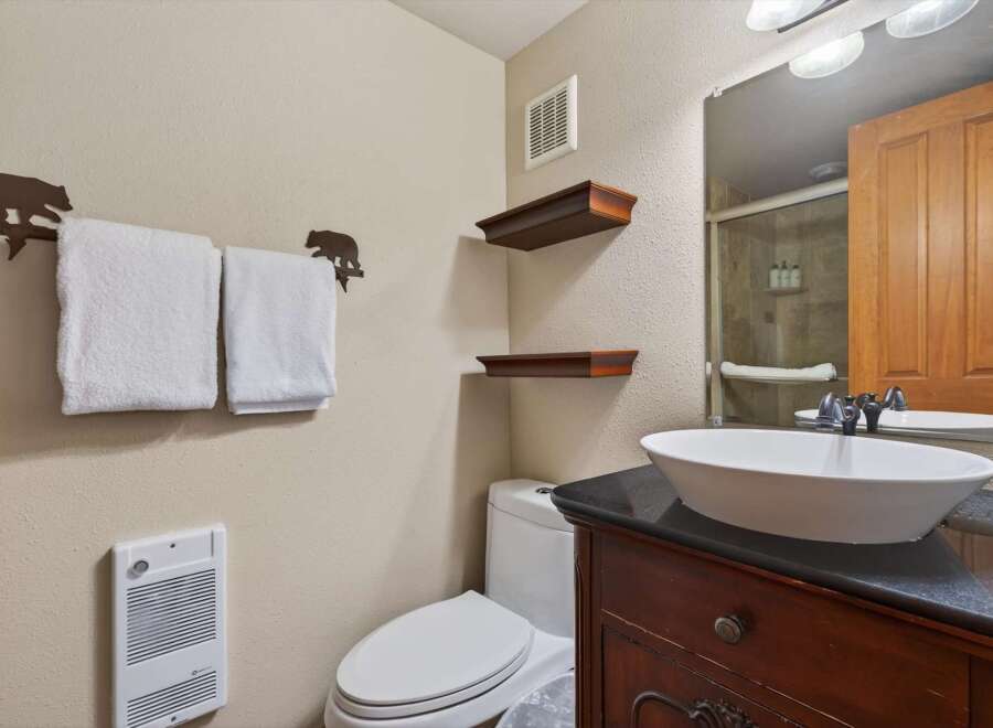 This charming bathroom features a stylish vanity with a sleek countertop and a modern vessel sink.