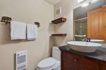 This charming bathroom features a stylish vanity with a sleek countertop and a modern vessel sink.
