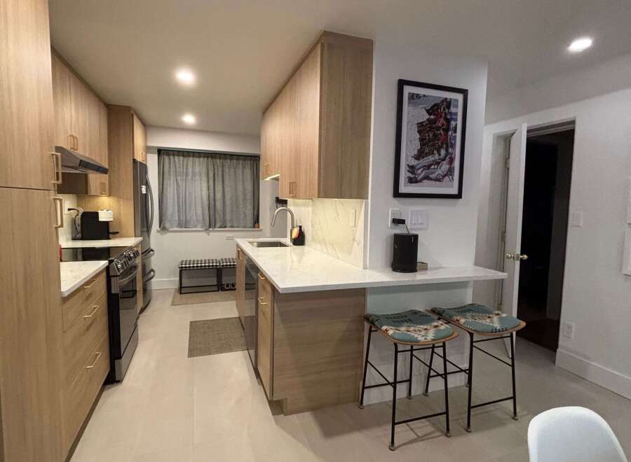 Step into this stunning kitchen, featuring sleek wooden cabinetry and modern appliances.