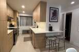 Step into this stunning kitchen, featuring sleek wooden cabinetry and modern appliances.